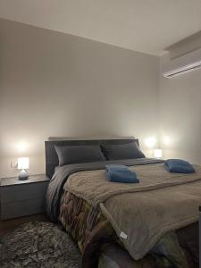 a bedroom with a bed with two blue pillows on it at Casa Verde Valsassina 2 in Primaluna