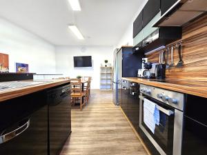 a kitchen with black cabinets and a wooden floor at Spacious House in Düsseldorf