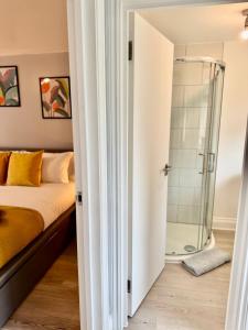 - une chambre avec une douche et un lit dans l'établissement Garden 1-Bed Flat 30min to Downtown & Free Parking, à Londres