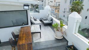 a balcony with a table and a television on a building at Penthouse with Jacuzzi,BBQ 2mn from sea Or Hakerem in Tel Aviv +35 photos