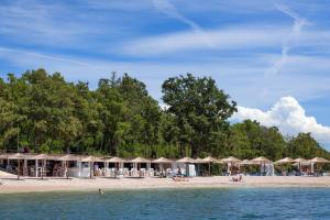 a beach with umbrellas and people on the beach at Evan Seaview in Funtana