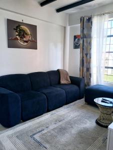 a living room with a blue couch and a table at Cozy Haven kitengela in Makandara