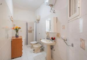 a white bathroom with a toilet and a sink at Chill e Relax Sul Mare in Sant'Isidoro +21 photos