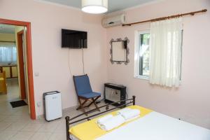 a bedroom with a bed and a blue chair at Ionian Sea in Nikiana