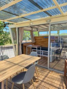 a screened porch with a wooden table and chairs at Bus hotel Playa Barrigona, entre Sàmara y Nosara in Sámara