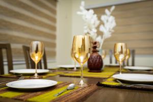 a table with three wine glasses and plates on it at Akwaaba Fie in Accra +45 photos