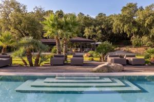 a swimming pool with chaise lounge chairs and a resort at Vallegrande Nature Resort by Geocharme in Cefalù