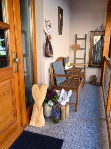 a porch with a bench and a table and flowers at Ferienwohnung Atelier in Bad Bellingen