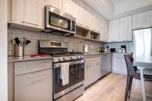 South EndModern Apt with Harbor Views的厨房配有不锈钢用具和白色橱柜