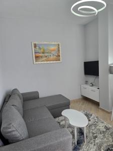 a living room with a couch and a tv at Prima Apartments in Pogradec