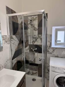 a shower in a bathroom with a washing machine at Living Room Orlando in Corigliano Calabro
