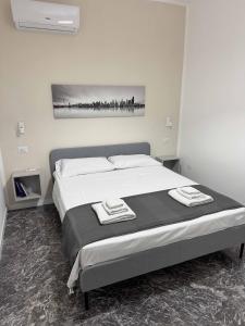 a bedroom with a bed with two towels on it at Living Room Orlando in Corigliano Calabro