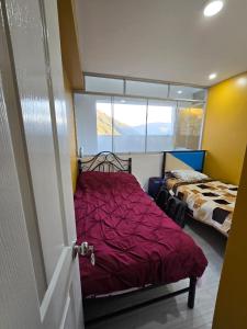 Abancayにある401 Moderno departamento equipadoの赤い掛け布団が敷かれたベッドのある寝室