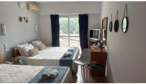 a hotel room with two beds and a television at Hotel Rodini in Kato Rodini