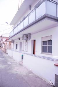 an empty street in front of a white building at Modern House Monolocali in Le Castella