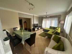 a living room with a green table and a couch at RELAX Apartman in Nyíregyháza