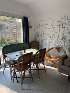 a living room with a table and chairs and a couch at Gîte du Cap Romain in Bernières-sur-Mer