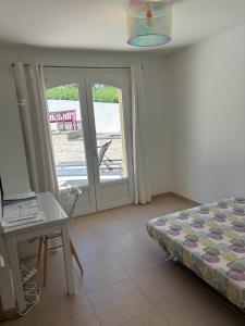 La NartelleにあるVilla Ste Maxime Piscine Proche Merのベッドと机と窓のある寝室 +16枚の写真