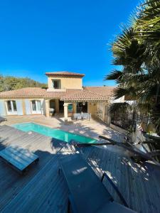 La NartelleにあるVilla Ste Maxime Piscine Proche Merの木製デッキにスイミングプールがある家