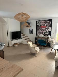 La NartelleにあるVilla Ste Maxime Piscine Proche Merのリビングルーム(テレビ、ソファ、椅子付)