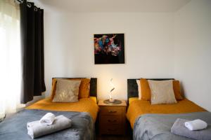 a bedroom with two beds with towels on them at Modern house , Perfect for business trip & Families holiday or working proffesionals-5 min from M1 J25 , 500MB Wi-Fi , Netflix , Fully equiped kitchen , Asda supermarket 5 min walk , Free Secure parking with CCTV ,available monthly deals in Nottingham