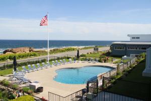 a view of a swimming pool and the ocean at Atlantis Oceanfront Inn Gloucester in Gloucester
