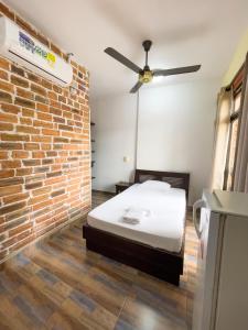 a bedroom with a bed and a brick wall at Hotel Casa Madrid in Puerto Berrío