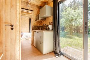 a kitchen in a tiny house with a large window at Tinyhouse et abeilles, séjour insolite en Provence in Orange