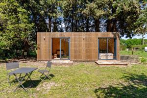 a small wooden house with two chairs and a table at Tinyhouse et abeilles, séjour insolite en Provence in Orange