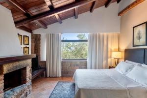 a bedroom with a bed and a fireplace at Vallegrande Nature Resort by Geocharme in Cefalù