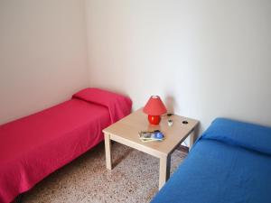 ein Schlafzimmer mit zwei Betten und einem Tisch mit Lampe in der Unterkunft TSUKY Holiday Home in Torre dellOrso in Torre dell'Orso