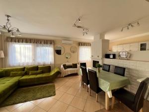 salon z zieloną kanapą i stołem w obiekcie RELAX Apartman w Nyíregyházie