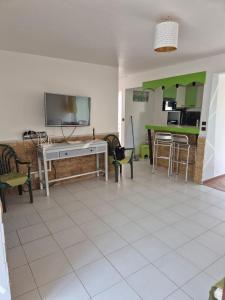 a living room with a tv and a table and chairs at Le Havre de paix in Sainte-Anne