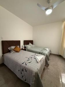 une chambre avec deux lits et un ventilateur de plafond dans l'établissement Estancia Luz y Armonía, à Casma 13 autres photos