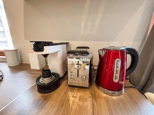 a red appliance sitting on top of a wooden table at Le Pavillon des Remparts - Commerces à proximité - Centre-ville - Appartement Cosy in Obernai
