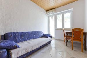 sala de estar con sofá azul y mesa en Apartments Galinec, en Metajna
