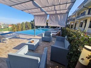 a patio with blue chairs and a swimming pool at B&B Casa Ciarpella in Montegranaro