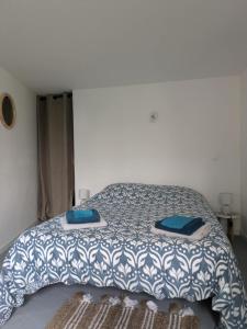 a bedroom with a bed with a blue and white comforter at Ti Louker - Appartement à 300m du Port in Locmiquélic