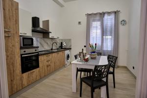 a kitchen with a table and chairs and a kitchen with a stove at Harmony Lux in Bagheria