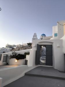 un bâtiment blanc avec une porte au milieu dans l'établissement Imarkellis Pyrgos Cave and Belfry Charm Santorini, à Pyrgos