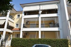 a white building with a car parked in front of it at Astros by the sea in Paralio Astros