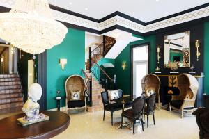 een kamer met groene muren en stoelen en een kroonluchter bij Cavalier South Beach Hotel in Miami Beach