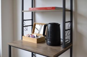 a coffee maker on a shelf in a room at AMA Home AMALI - Geräumiges Apartment mit Balkon & Parkplatz - Perfekt für Business & Erholung in Hiddenhausen