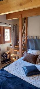 a bedroom with a bed and a bunk ladder at Les Châtaigniers Gîtes du Mas Haut in Saint-Jean-du-Gard
