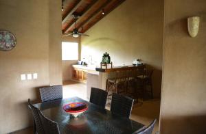 a dining room with a table and chairs and a kitchen at Las Villas, Villa Alegria,Troncones in Troncones
