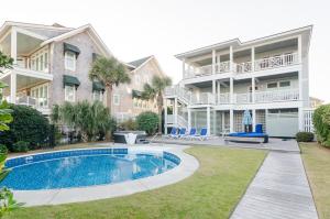 a house with a swimming pool in front of it at Blake Cottage by Bryant Real Estate in Wrightsville Beach