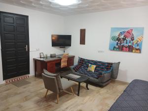 a living room with a couch and a table and a tv at Villa Mango in Abidjan