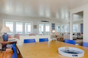 a living room with a table and blue chairs at Blake Cottage by Bryant Real Estate in Wrightsville Beach