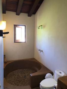 a bathroom with a bath tub and a toilet at Las Villas, Villa Alegria,Troncones in Troncones