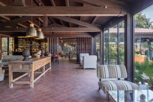 an open patio with a table and chairs and windows at Vallegrande Nature Resort by Geocharme in Cefalù